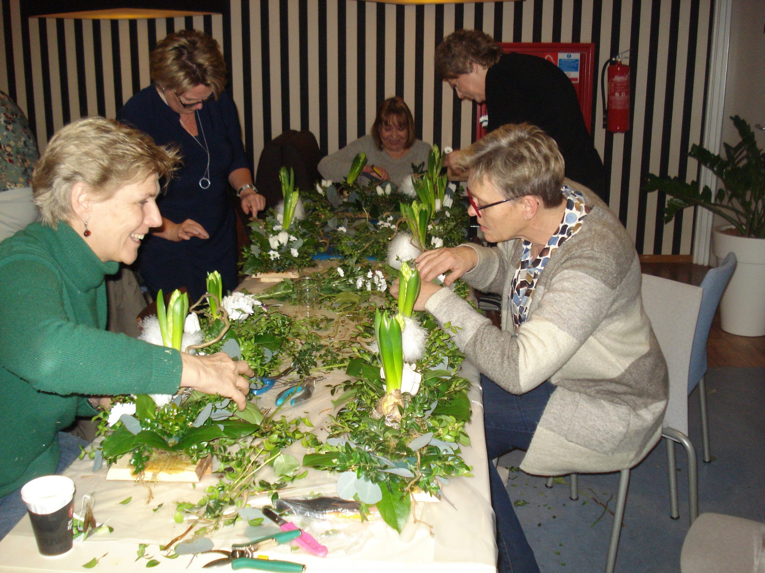 Collega’s maken een bloemstuk tijdens een workshop